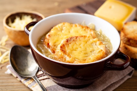 French onion soup with croutons and cheese on rustic wooden table. Selective focus.の写真素材