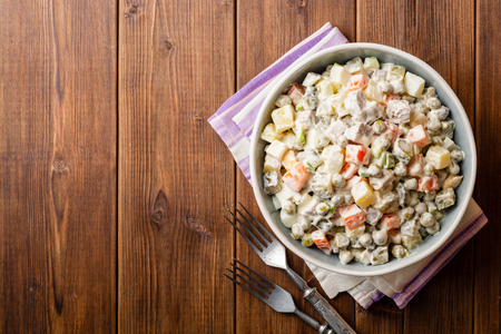 Traditional Russian salad Olivier in bowl on wooden table. Top view. Copy space.の写真素材