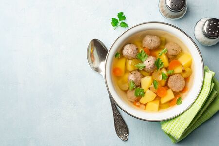 Soup with meatballs and vegetables in bowl on concreteの写真素材