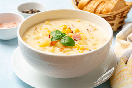 Corn chowder soup in white bowl on concrete background. Selective focus.の写真素材