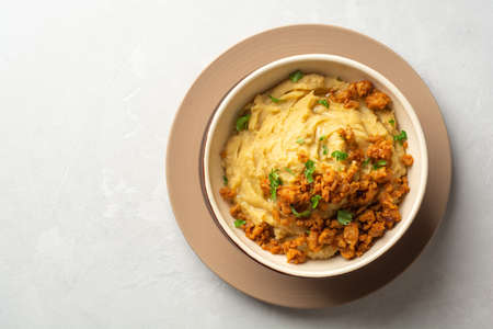 Yellow pea puree or porridge or pudding with meat sauce in bowl on concrete background. Top view, copy space.の写真素材