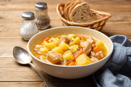 Meat stew with potato and carrot in bowl on wooden background. selective focus.の写真素材