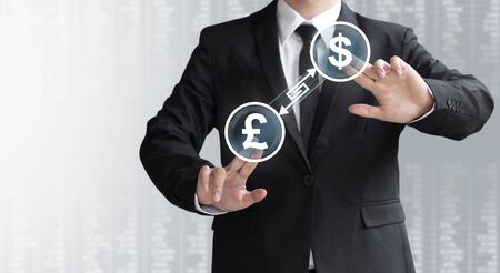 business man show currency converter or exchange Dollar and Pound, money for investmentの写真素材