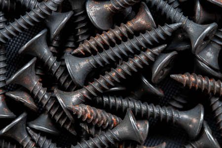 Stack of black stainless steel screw, equipment construction backgroundの写真素材
