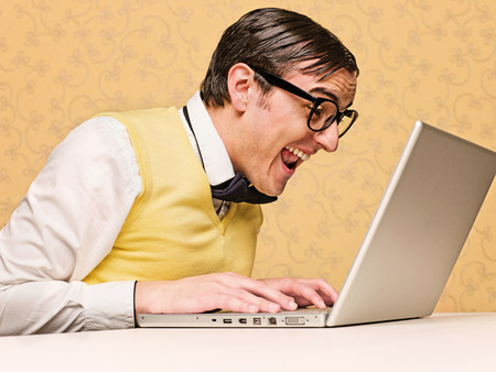 Young nerd sitting at the computerの写真素材