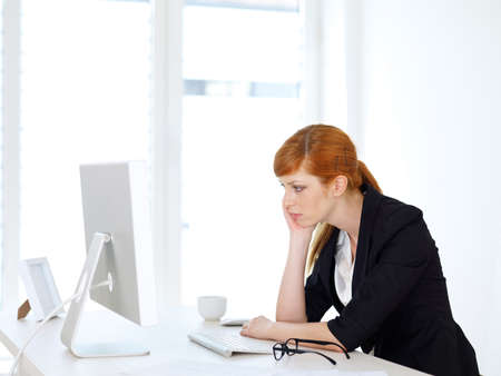 Bored Businesswoman typing on the computerの写真素材