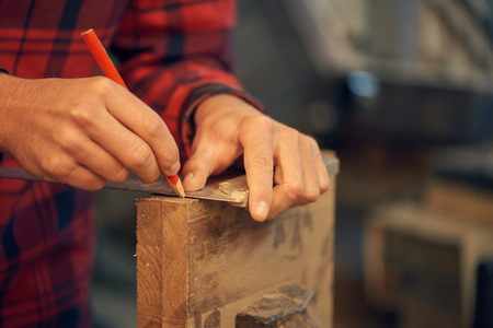 Carpenter measuring woodの写真素材