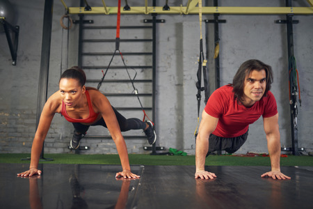 Man and woman working out in gymの写真素材