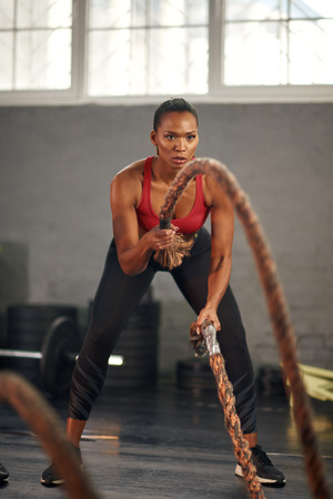 Woman working out with ropes in gymの写真素材