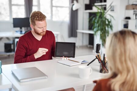 Handsome Caucasian manager showing on tablet to his employee business strategy. Start up business concept.の写真素材