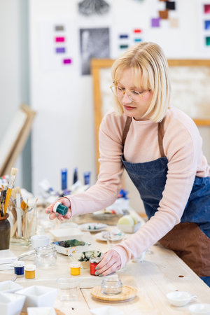 Female potter working with clay in pottery class at art studioの写真素材
