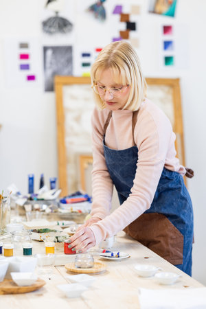 Portrait of female potter working on ceramic product in pottery workshopの写真素材