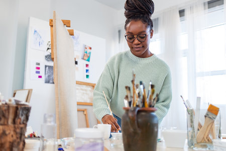 Portrait of african american female artist painting picture in art studioの写真素材