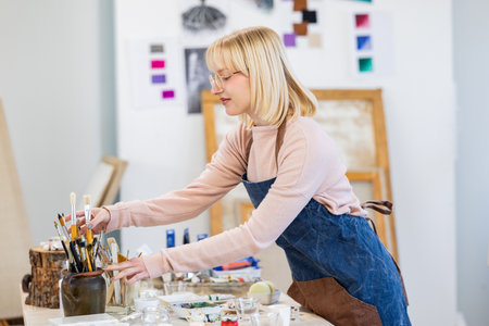 Portrait of a female artist working on her painting in a studioの写真素材