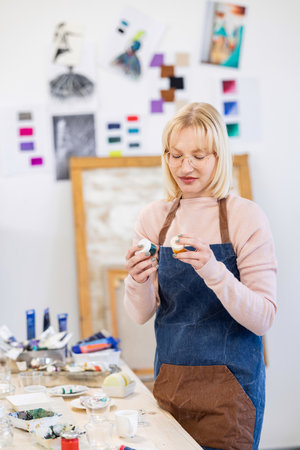 Portrait of a female artist painting a picture in her studio.の写真素材