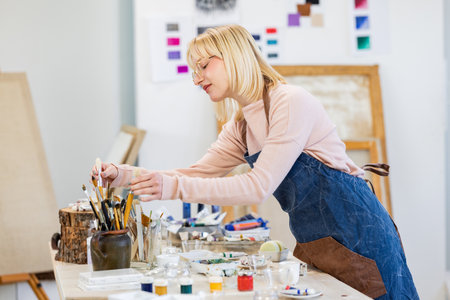 Portrait of a female artist painting on canvas in her studio.の写真素材