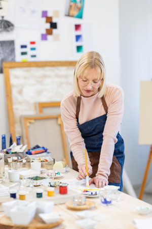 Portrait of a female artist painting on a canvas in her studioの写真素材