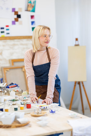 Portrait of a female artist painting on canvas in her studio.の写真素材