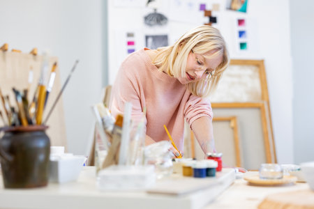 Portrait of a female artist working on a painting in her studioの写真素材