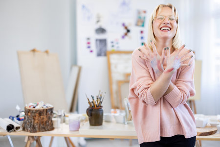 Portrait of smiling female artist standing in her studio and looking at cameraの写真素材