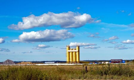 Landscape with cement plant  Cement plant in the field with grass and cloudsの写真素材