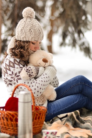 Beautiful, attractive, cute, lovely girl, kid, babe, hugging, embracing cute, white, tiny, small teddy bear, winter, snow, gift, year, sweater, lantern, cold, forest, background, holiday, fun, joy, childhood, xmas, celebrate, box, merry, snowflake, firの写真素材