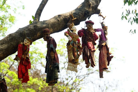 Statues of angels hanging on a tree in a temple in Indiaの写真素材