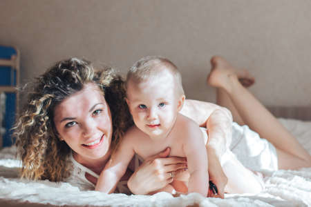 mother and baby lie on bedの写真素材
