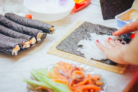hands making sushi rolls at homeの写真素材