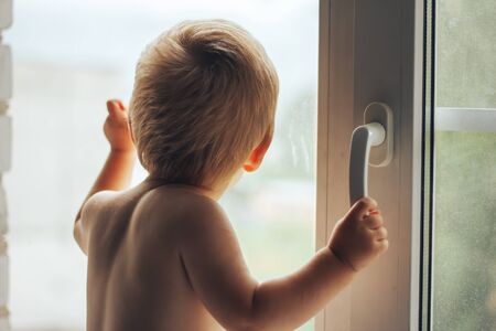 baby hand opens the white plastic the window. on white background.の写真素材