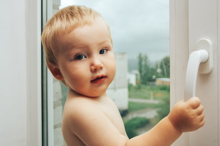 baby is opening window it is dangerousの写真素材