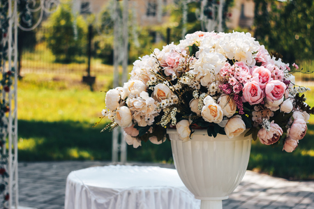 artificial flowers on the street in white potの写真素材