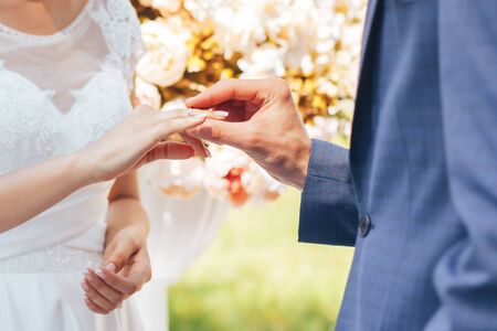 Groom with the bride putting their rings to each otherの写真素材