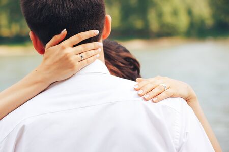 hands of bride on the neck of fianceの写真素材