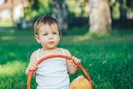 Beautiful little baby look at the sky against blue green grass.の写真素材