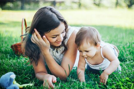 Mother and daughter lying on the grass. legged childの写真素材