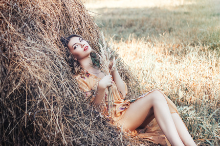 beautiful young girl lie on hayrickの写真素材