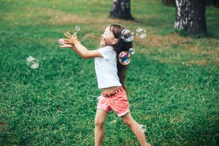 little girl playing with soap bubblesの写真素材