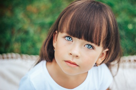 little beautiful cute girl looking at camera blue eyesの写真素材
