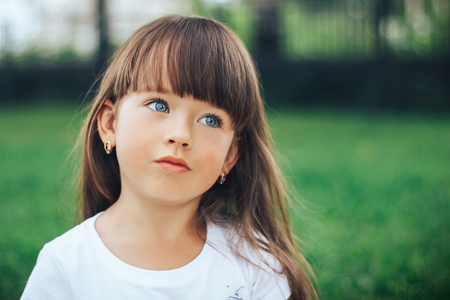 close up portrait of little dreaming girl with blue eyesの写真素材