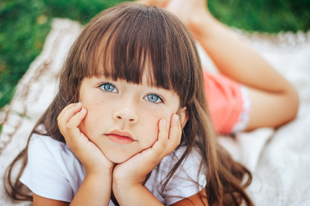 little beautiful cute girl looking at camera blue eyesの写真素材