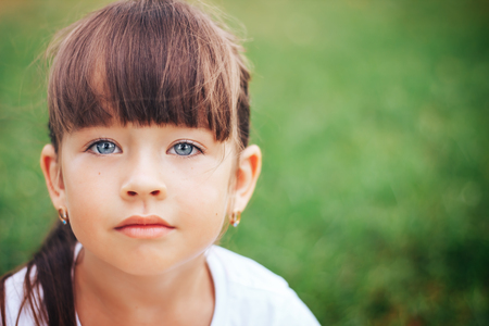 little beautiful cute girl looking at camera blue eyesの写真素材