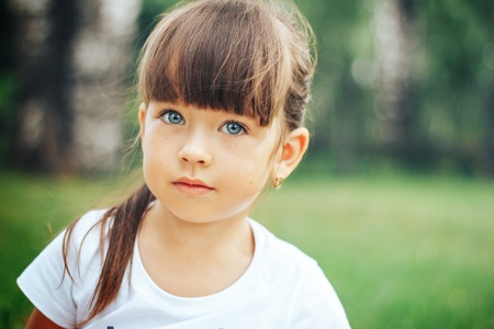 little beautiful cute girl looking at camera blue eyesの写真素材