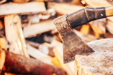 The wood chopper sticks out in wooden hemp. Ax and ax handle. Woodworking. Deforestation by a sharp...