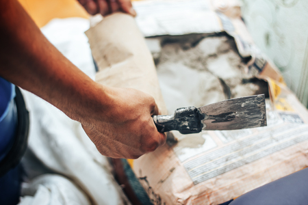 the worker applies glue for a tile on a spatulaの写真素材
