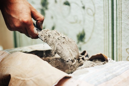 the worker applies glue for a tile on a spatulaの写真素材
