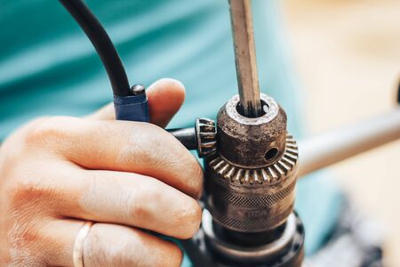 Electric screwdriver in hand of worker, drill replacementの写真素材