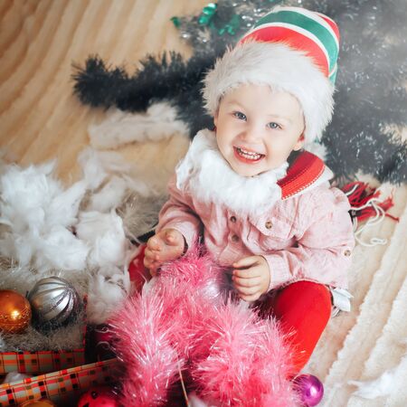 Christmas Baby in Santa Hat, Child near Present Gift Box over Holiday backgroundの写真素材