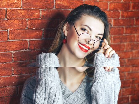 Picture of charming young woman in stylish eyewear looking at camera with smile teeth, having happy joyful expression. Attractive female advertising optics, wearing round glasses. Red lips.の写真素材