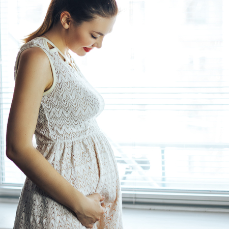 pregnancy, motherhood, people and expectation concept - close up of happy pregnant woman with big...
